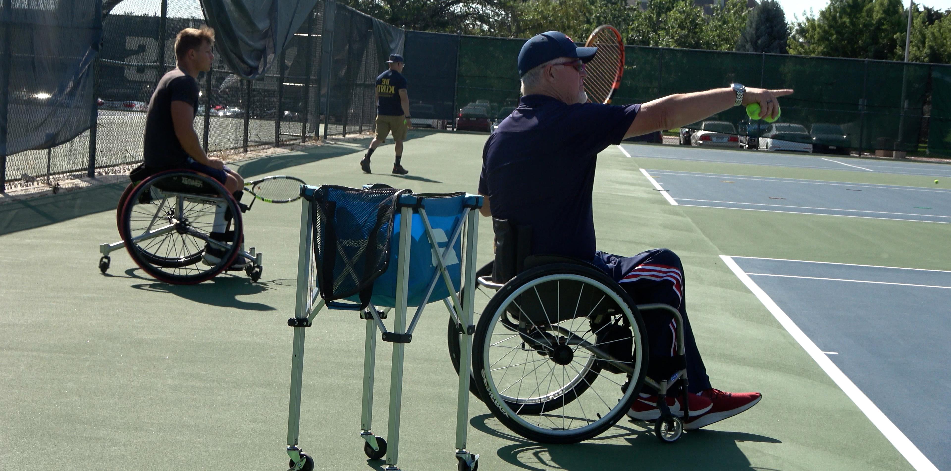 斯科特道格拉斯教练轮椅网球举起他的手臂，指着